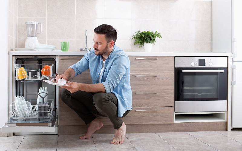 Man unloading dishwasher