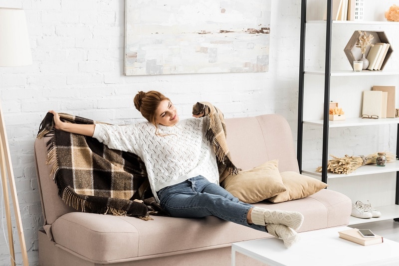 woman on couch with warm clean wool blanket