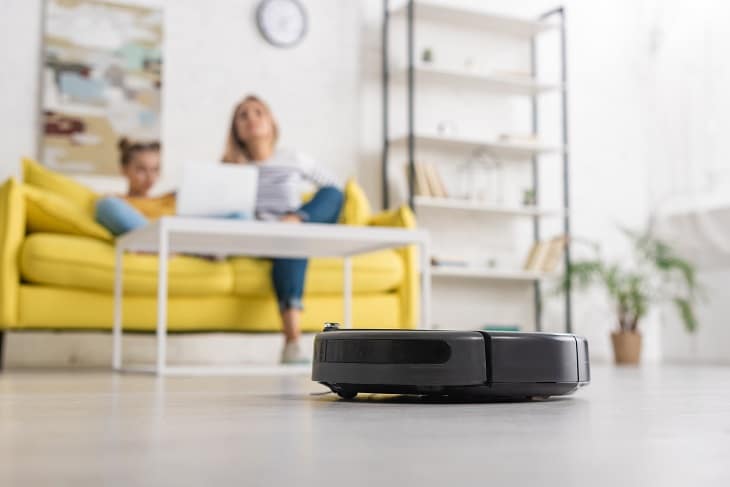 how to choose the best robot vacuum - mother and daughter relaxing while robot vacuum cleans floor